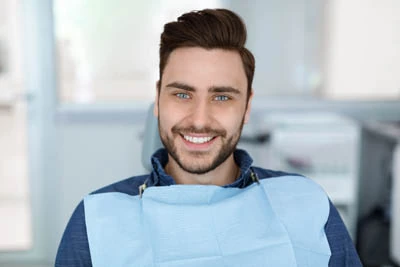 man smiling after Invisalign helped straighten his teeth